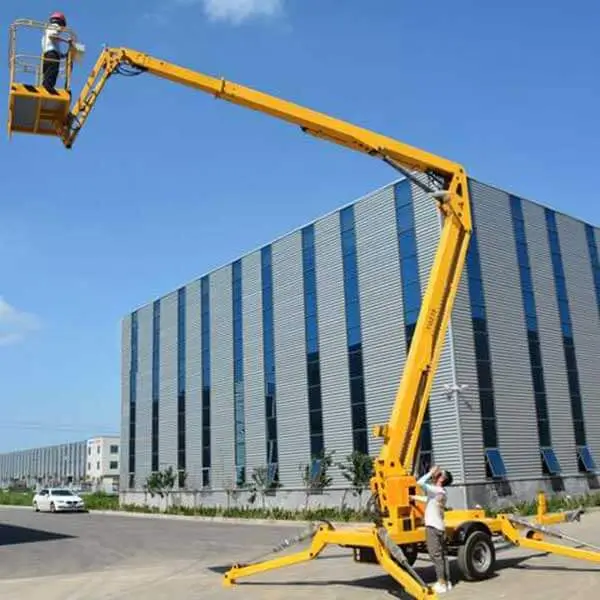 Yellow articulating boom lift outside industrial warehouse facility