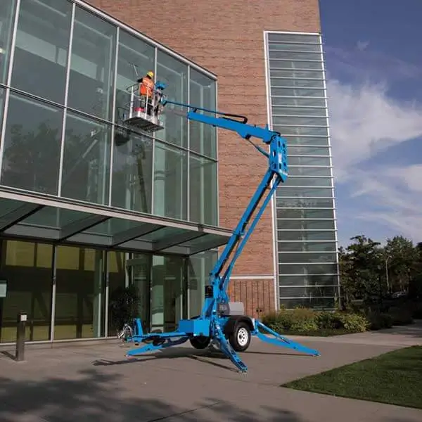 Blue boom lift operator cleaning commercial glass building facade