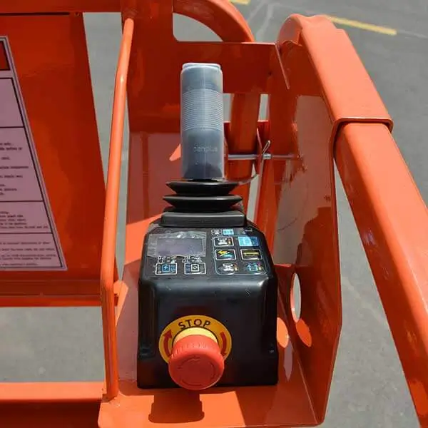 Close-up of industrial safety joystick handle and emergency stop switch on lift platform