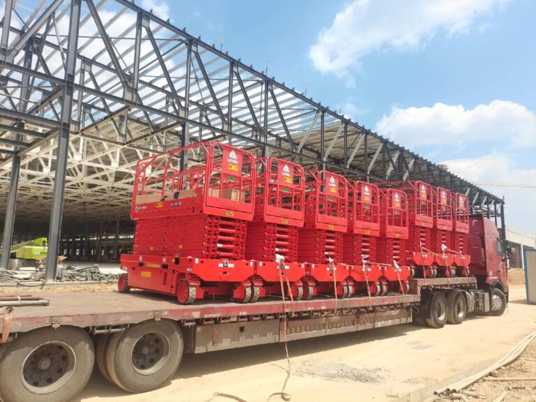 Red electric scissor lifts with different scissor lift working height options loaded on a truck for export