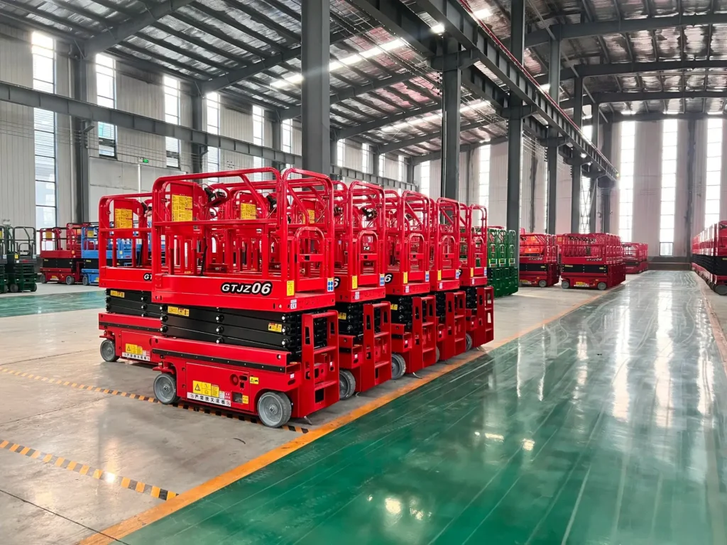 DADE® Machinery CE certified scissor lift neatly arranged inside a warehouse, demonstrating large inventory, factory production capacity, and ready-to-ship aerial work platforms for global customers.